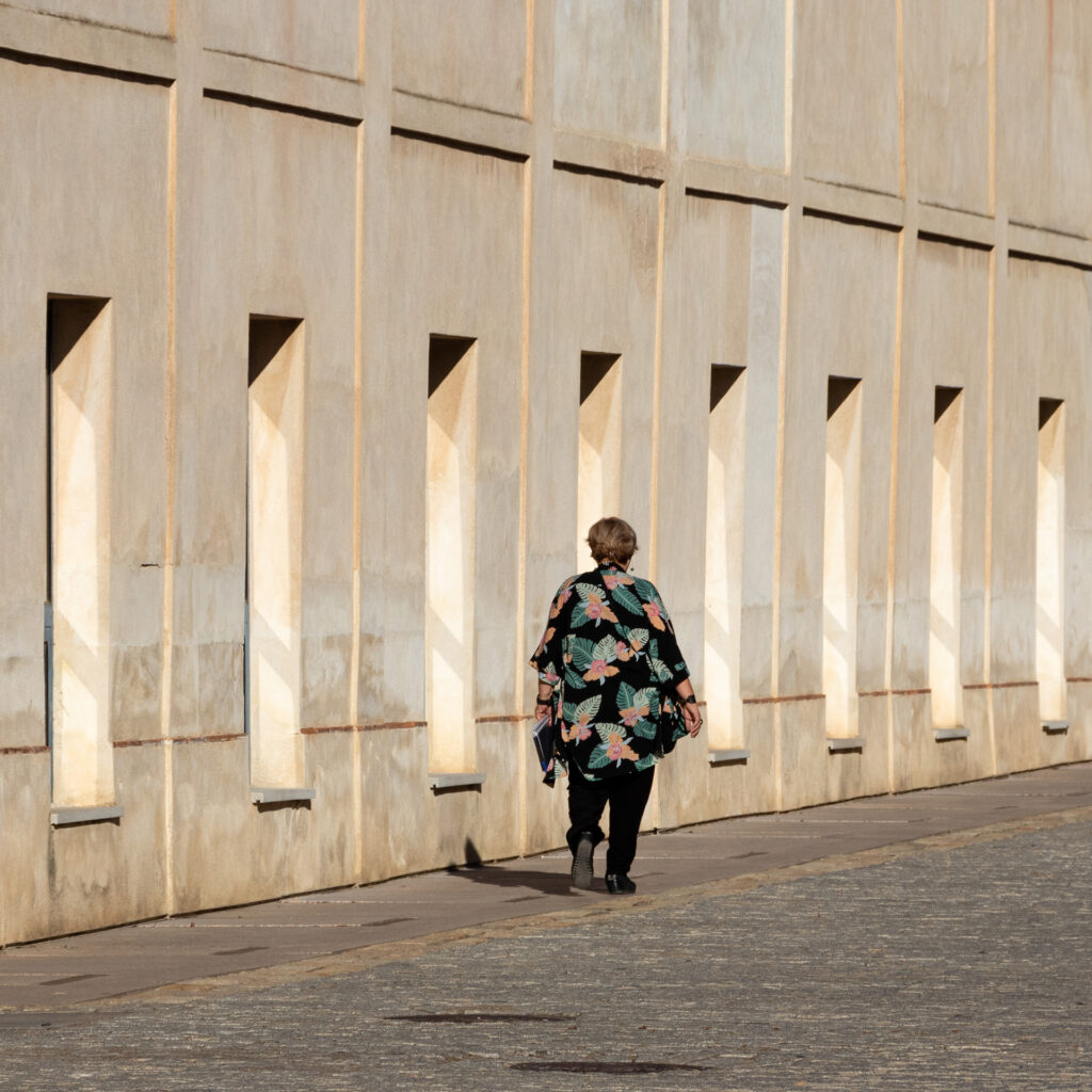 Frau läuft vor einer Wand am Centro Andaluz de Arte Contemporáneo in Sevilla