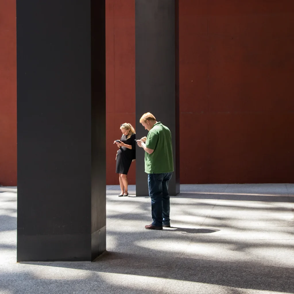 Zwei Menschen, die auf ihre Smartphones starren